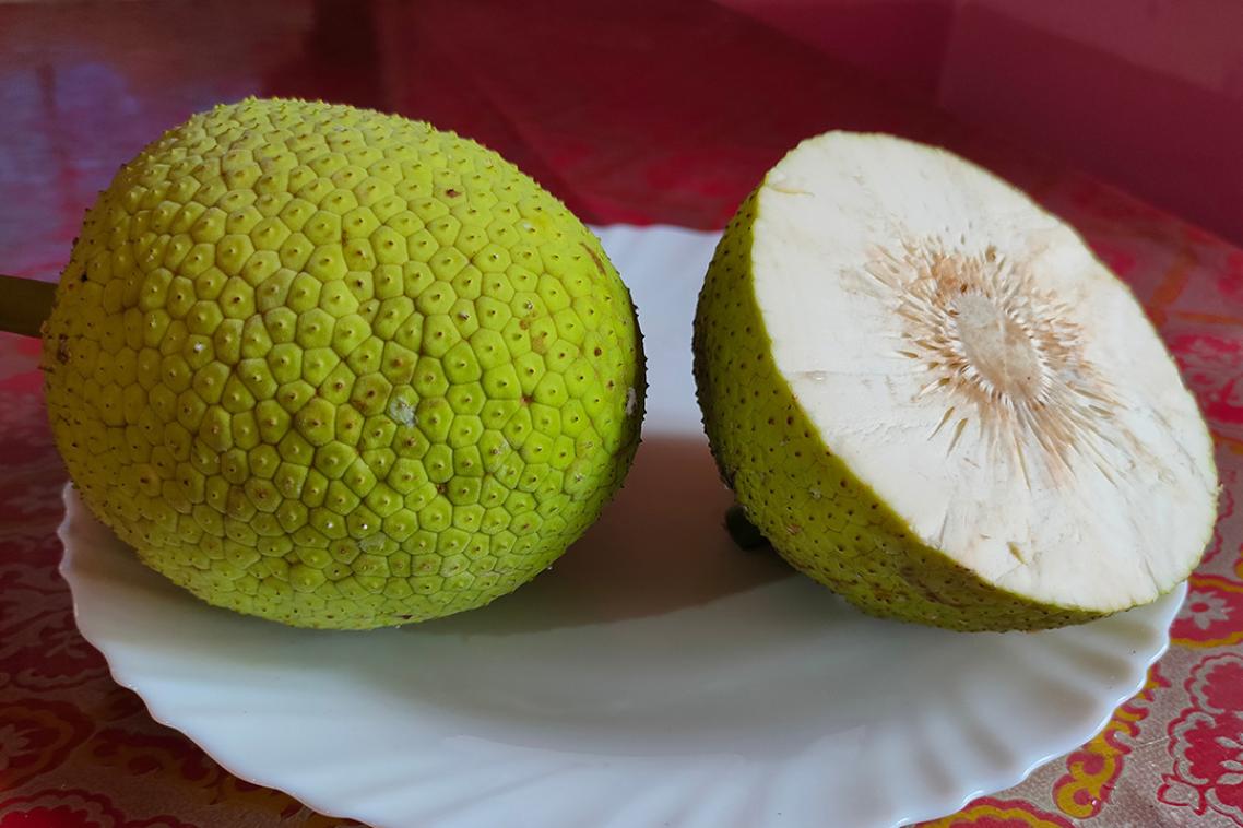 Two large pieces of a melon-looking fruit with green prickly skin